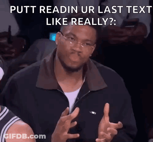 A Man Wearing Glasses Is Making A Funny Face While Sitting In A Stadium . GIF