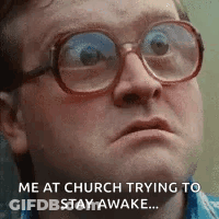 A Man Wearing Glasses Is Making A Funny Face While Trying To Stay Awake . GIF