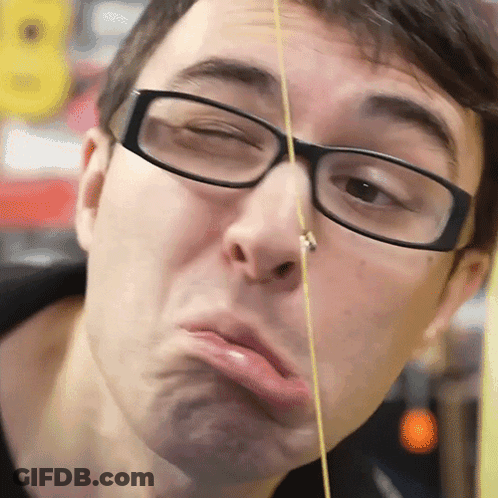 A Man Wearing Glasses Is Making A Funny Face With A String In His Nose GIF