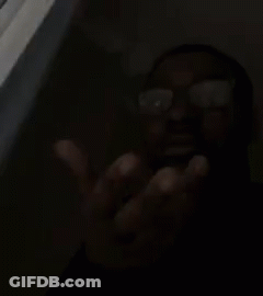 A Man Wearing Glasses Is Making A Funny Face With His Hand . GIF