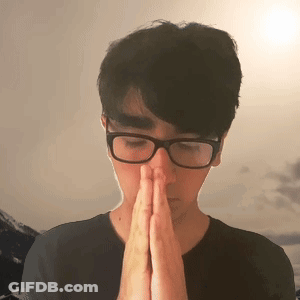 A Man Wearing Glasses Is Praying With His Hands Folded GIF