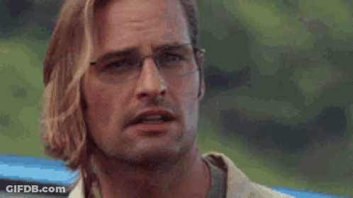 A Man Wearing Glasses Is Scratching His Face . GIF