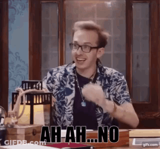 A Man Wearing Glasses Is Sitting At A Table And Making A Funny Face And Saying Ah-Ah-No . GIF