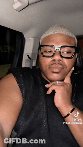 A Man Wearing Glasses Is Sitting In A Car GIF