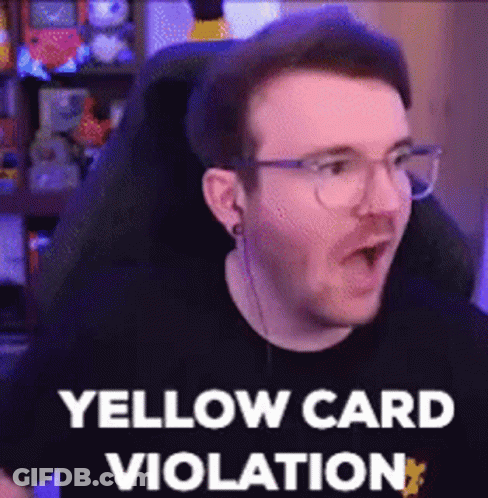 A Man Wearing Glasses Is Sitting In A Chair And Making A Funny Face While Saying Yellow Card Violation . GIF