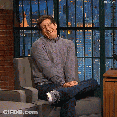 Smiling Man With Glasses Sitting Cross-Legged GIF