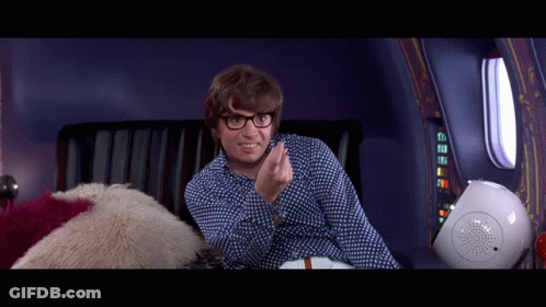 A Man Wearing Glasses Is Sitting On A Couch And Smiling GIF