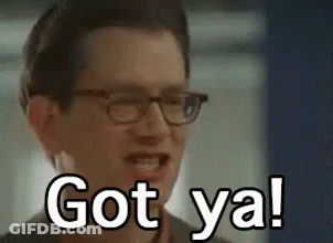 A Man Wearing Glasses Is Smiling And Saying `` Got Ya ! '' GIF