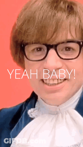 A Man Wearing Glasses Is Smiling And The Words Yeah Baby Are Behind Him GIF