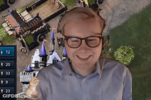 A Man Wearing Glasses Is Smiling In Front Of A Video Game Screen With The Number 12 On It GIF