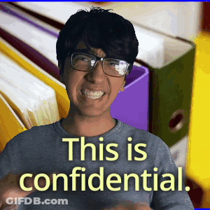 A Man Wearing Glasses Is Smiling In Front Of Binders That Say This Is Confidential GIF
