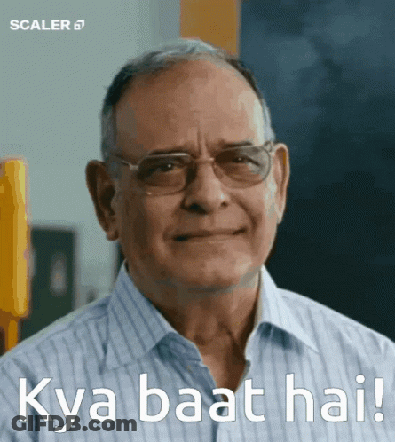 A Man Wearing Glasses Is Smiling With The Words Kya Baat Hai Written Below Him GIF