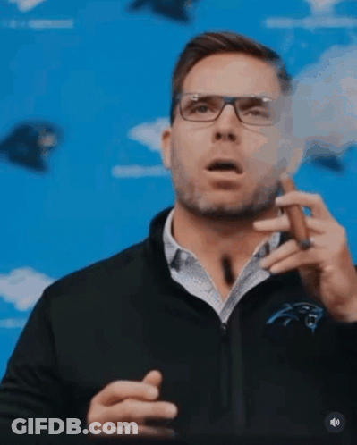 A Man Wearing Glasses Is Smoking A Cigar GIF