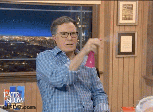 A Man Wearing Glasses Is Spraying Something With A Spray Bottle On A Late Show Live Show GIF