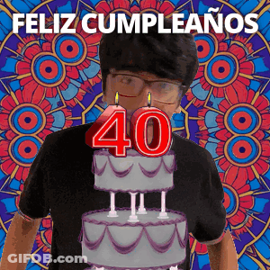A Man Wearing Glasses Is Standing In Front Of A Birthday Cake With The Number 40 On It GIF