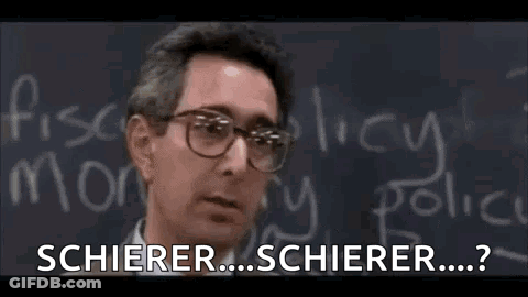 A Man Wearing Glasses Is Standing In Front Of A Blackboard With Chalk Writing On It . GIF