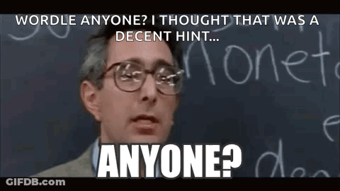 A Man Wearing Glasses Is Standing In Front Of A Blackboard With The Words `` Wordle Anyone '' Written On It . GIF