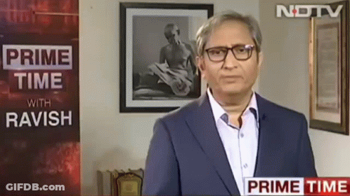 A Man Wearing Glasses Is Standing In Front Of A Sign That Says Prime Time With Ravish GIF
