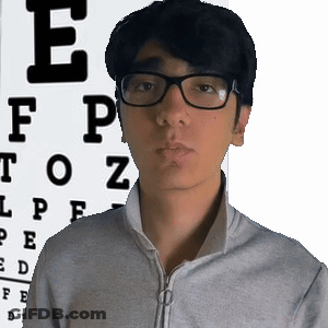 A Man Wearing Glasses Is Standing In Front Of An Eye Chart With The Letter E On It GIF