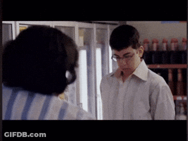 A Man Wearing Glasses Is Standing Next To A Woman In A Striped Shirt GIF