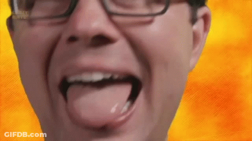 A Man Wearing Glasses Is Sticking His Tongue Out In Front Of A Yellow Background . GIF