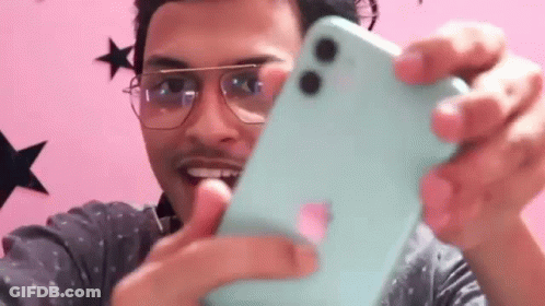 A Man Wearing Glasses Is Taking A Selfie With A Blue Iphone . GIF
