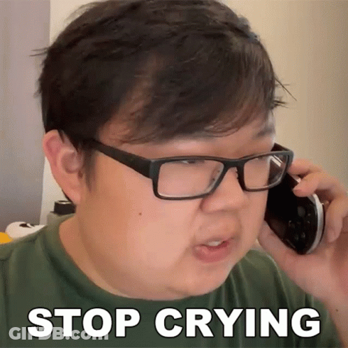 A Man Wearing Glasses Is Talking On A Cell Phone And Has The Words Stop Crying Written On His Face GIF