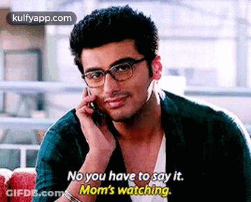 A Man Wearing Glasses Is Talking On A Cell Phone And Saying `` No You Have To Say It . Mom 'S Watching '' GIF