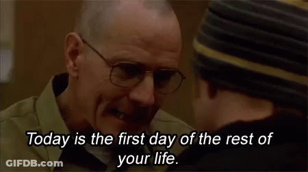 A Man Wearing Glasses Is Talking To Another Man In A Hat . GIF