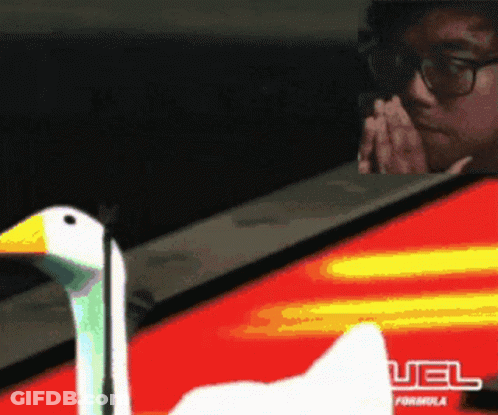A Man Wearing Glasses Looks At A Swan In Front Of A Red And Yellow Sign That Says Uel Formula GIF