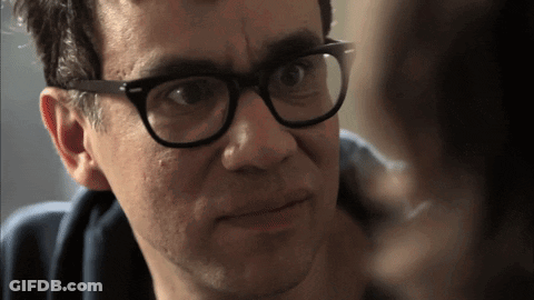 A Man Wearing Glasses Looks At Another Man GIF