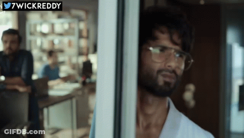 A Man Wearing Glasses Looks Out Of A Window With A Twitter Logo Above Him GIF
