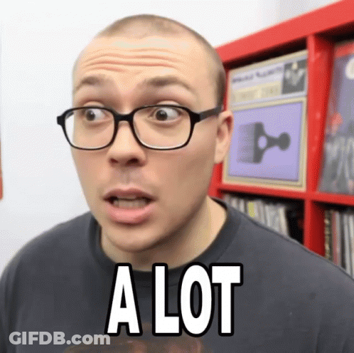 A Man Wearing Glasses Says A Lot In Front Of A Bookshelf GIF