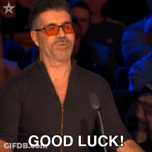A Man Wearing Glasses Says " Good Luck " In Front Of A Crowd GIF