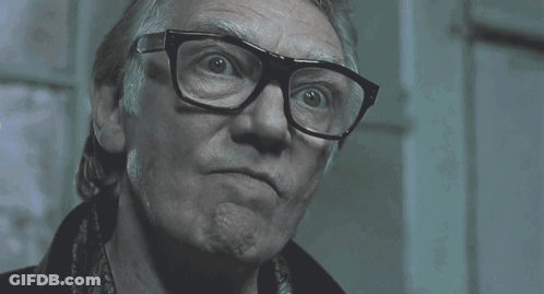 A Man Wearing Glasses Says Me !!! In A Dark Room GIF