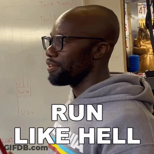 A Man Wearing Glasses Says Run Like Hell In Front Of A White Board GIF