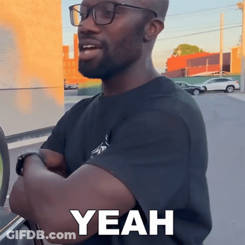 A Man Wearing Glasses Says Yeah While Standing In Front Of A Car GIF