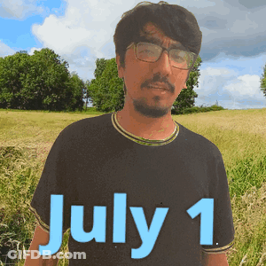 A Man Wearing Glasses Stands In A Field With The Date July 1 On His Shirt GIF