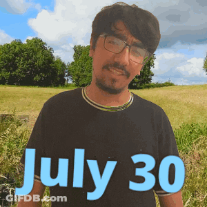 A Man Wearing Glasses Stands In A Field With The Date July 30 GIF