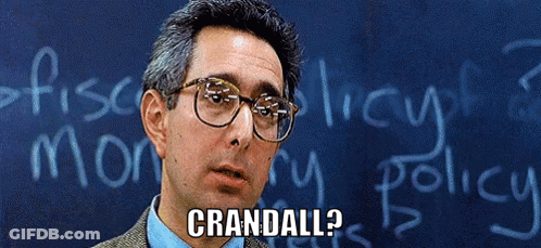 A Man Wearing Glasses Stands In Front Of A Blackboard That Says Crandell On It GIF