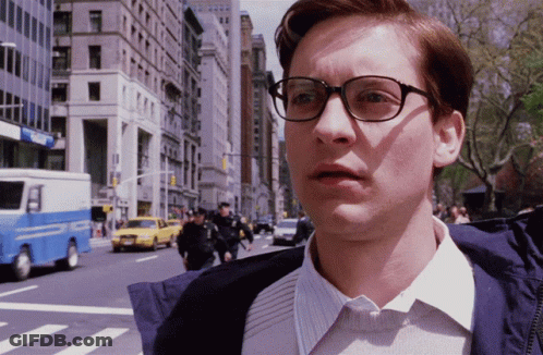 A Man Wearing Glasses Stands In Front Of A Blue And White Police Truck GIF
