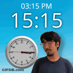 A Man Wearing Glasses Stands In Front Of A Clock That Says 15:15 GIF