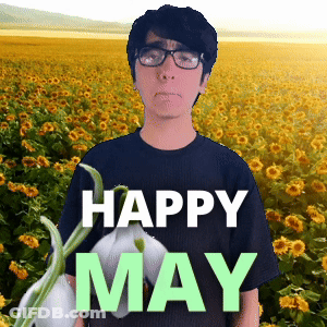 A Man Wearing Glasses Stands In Front Of A Field Of Sunflowers With The Words " Happy May " On The Bottom GIF