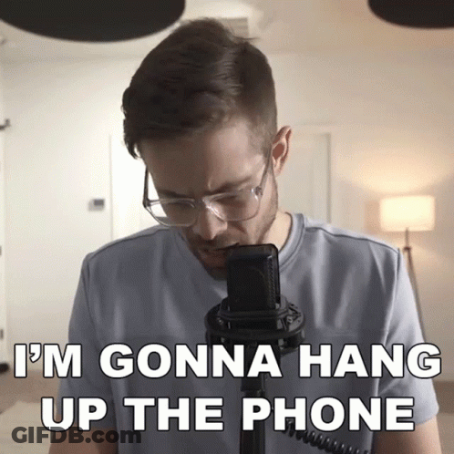 A Man Wearing Glasses Stands In Front Of A Microphone With The Words " I 'M Gonna Hang Up The Phone " Below Him GIF