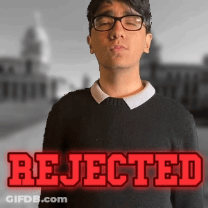 A Man Wearing Glasses Stands In Front Of A Sign That Says Rejected In Red Letters GIF