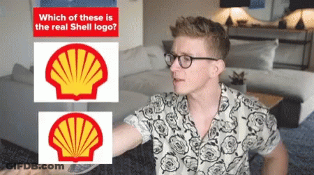 A Man Wearing Glasses Stands In Front Of Two Shell Logos GIF