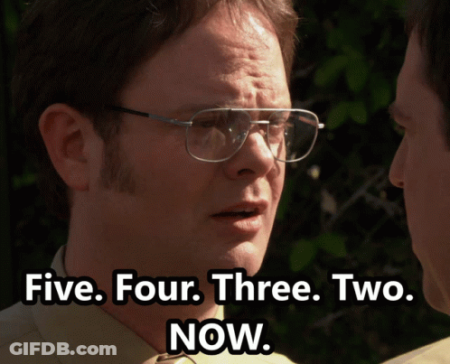 A Man Wearing Glasses Talks To Another Man With The Words Five Four Three Two Now Below Him GIF