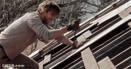 A Man Wearing Gloves Is Working On A Wooden Roof GIF