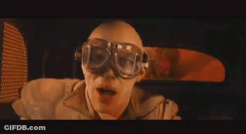 A Man Wearing Goggles Is Sitting In A Car And Making A Funny Face . GIF