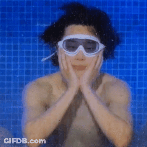 A Man Wearing Goggles Is Swimming In A Blue Pool GIF